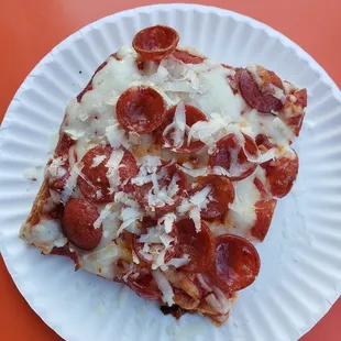 a slice of pepperoni pizza on a paper plate