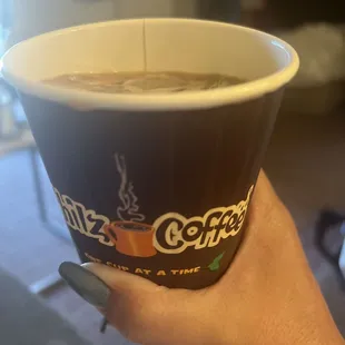 a hand holding a cup of coffee