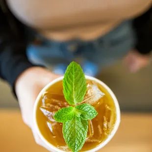 a person holding a cup of iced coffee
