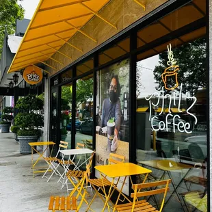 a yellow table and chairs outside a coffee shop