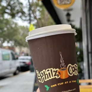 a hand holding a cup of coffee