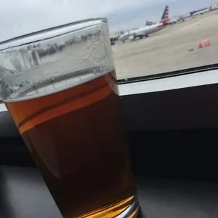 a glass of beer on a window sill