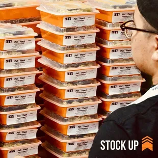 a man standing in front of a stack of food