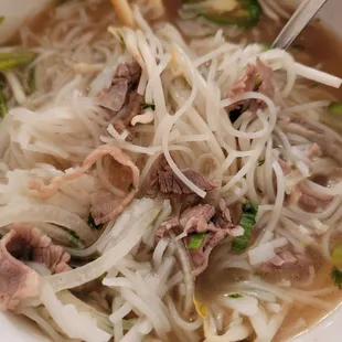 a bowl of noodles with meat and vegetables