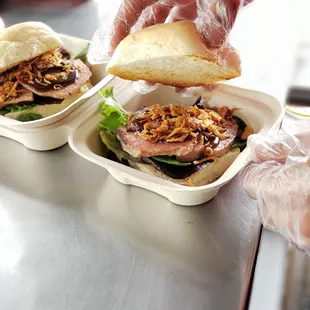  a person putting a sandwich in a container