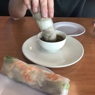 a person dipping food into a bowl