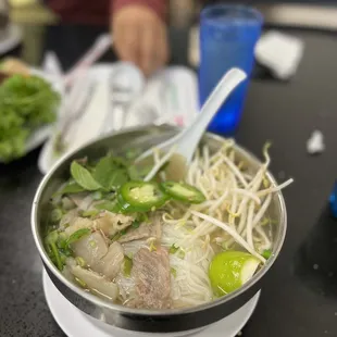 a bowl of pho with meat and vegetables