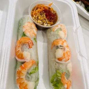 a tray of fresh spring rolls and a bowl of dipping sauce