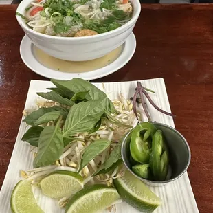 Seafood pho and it&apos;s beansprout, lime, fresh basil and some jalapeños
