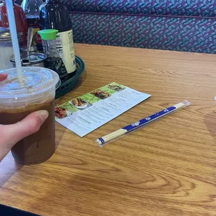 Vietnamese iced coffee, table, menu, chopsticks, and the condiments.