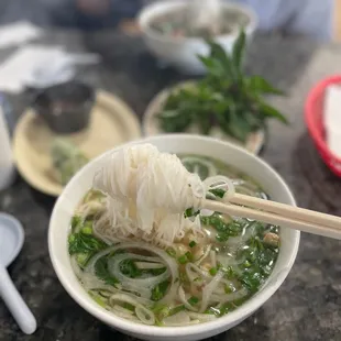 a bowl of noodles with chopsticks