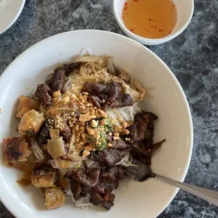 a bowl of noodles with meat and vegetables