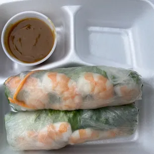 a tray of rice rolls with dipping sauce
