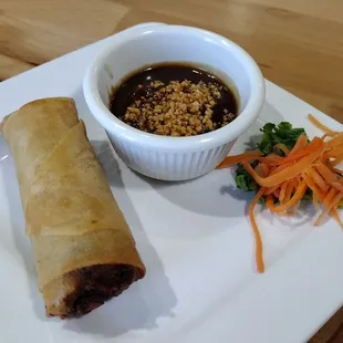 Egg roll with peanut sauce.
