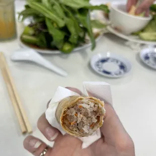 a person holding a roll of food