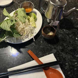 a plate of food with chopsticks and sauce