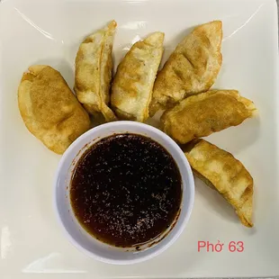 a plate of dumplings with dipping sauce