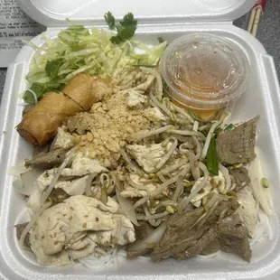 Thin rice noodles with chicken, beef, spring rolls, lettuce, fish sauce, bean sprouts, and chopped lettuce