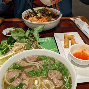 a person eating a bowl of pho with chopsticks