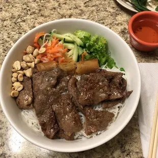 Vermicelli bowl with grilled beef and egg roll