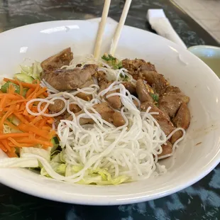 a bowl of noodles with meat and vegetables