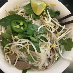 a bowl of noodles with meat and vegetables