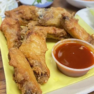 a plate of fried chicken wings with dipping sauce
