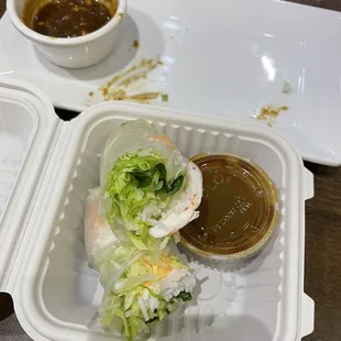 a takeout container with a salad and dipping sauce