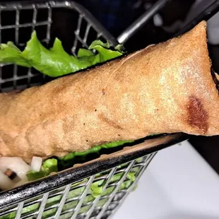 a basket of food with a vegetable wrap in it