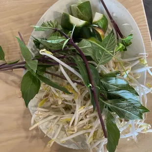 When ordering Pho, you receive a plate of the sides which include jalapeños, thai basil, lime wedges, and bean sprouts.