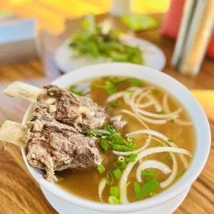 a bowl of soup with meat and noodles