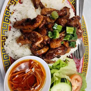 a plate of food with rice, meat and vegetables