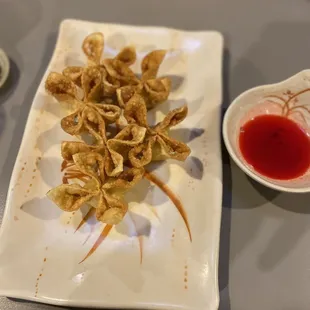 a plate of wontons and sauce