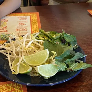 a plate of noodles and limes