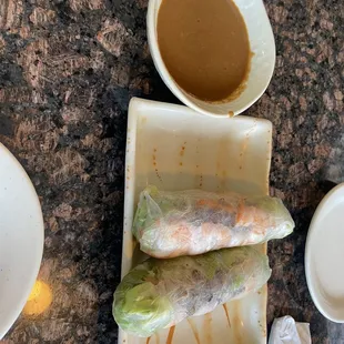 a plate of spring rolls and a bowl of dipping sauce