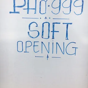 a sign for a soft opening