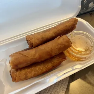 two rolls of food in a styrofoam container