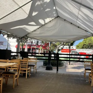 tables and chairs under a tent