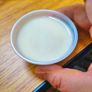 a person holding a bowl of milk