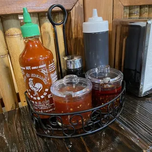 Table condiments: sambal, chili oil, sriracha, soy sauce, hoisin sauce