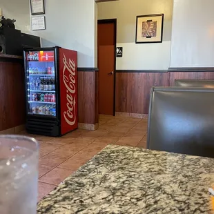 a soda cooler and a table in a restaurant