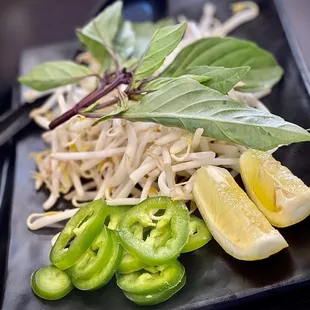 Pho side of bean sprouts, basil, jalapeño and lemon wedges