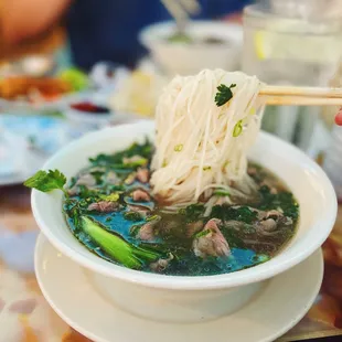 a bowl of soup with chopsticks