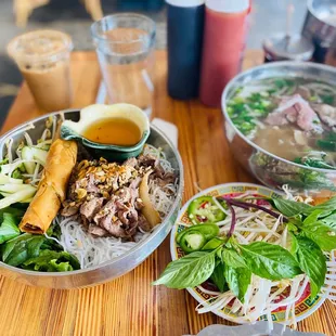 Pho dac biet and vermicelli bowl with egg roll and beef.