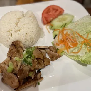 a plate of food with rice, meat and vegetables