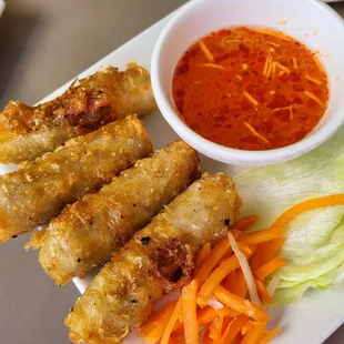 a plate of food and a bowl of dipping sauce