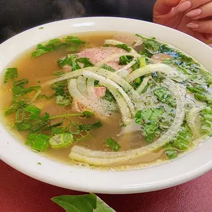 a bowl of soup with meat and vegetables