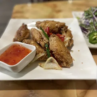 a plate of fried chicken with a side of salad