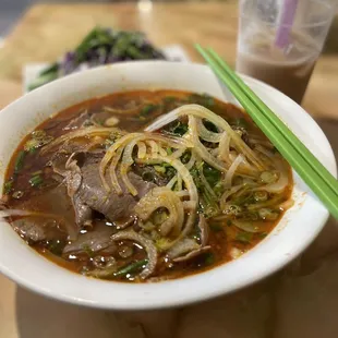 a bowl of soup with chopsticks