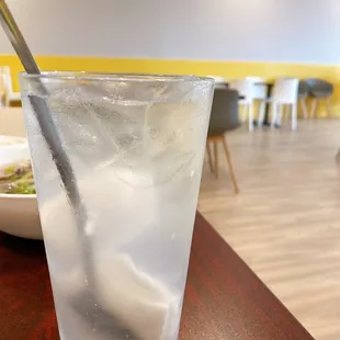 a glass of water with ice and a spoon